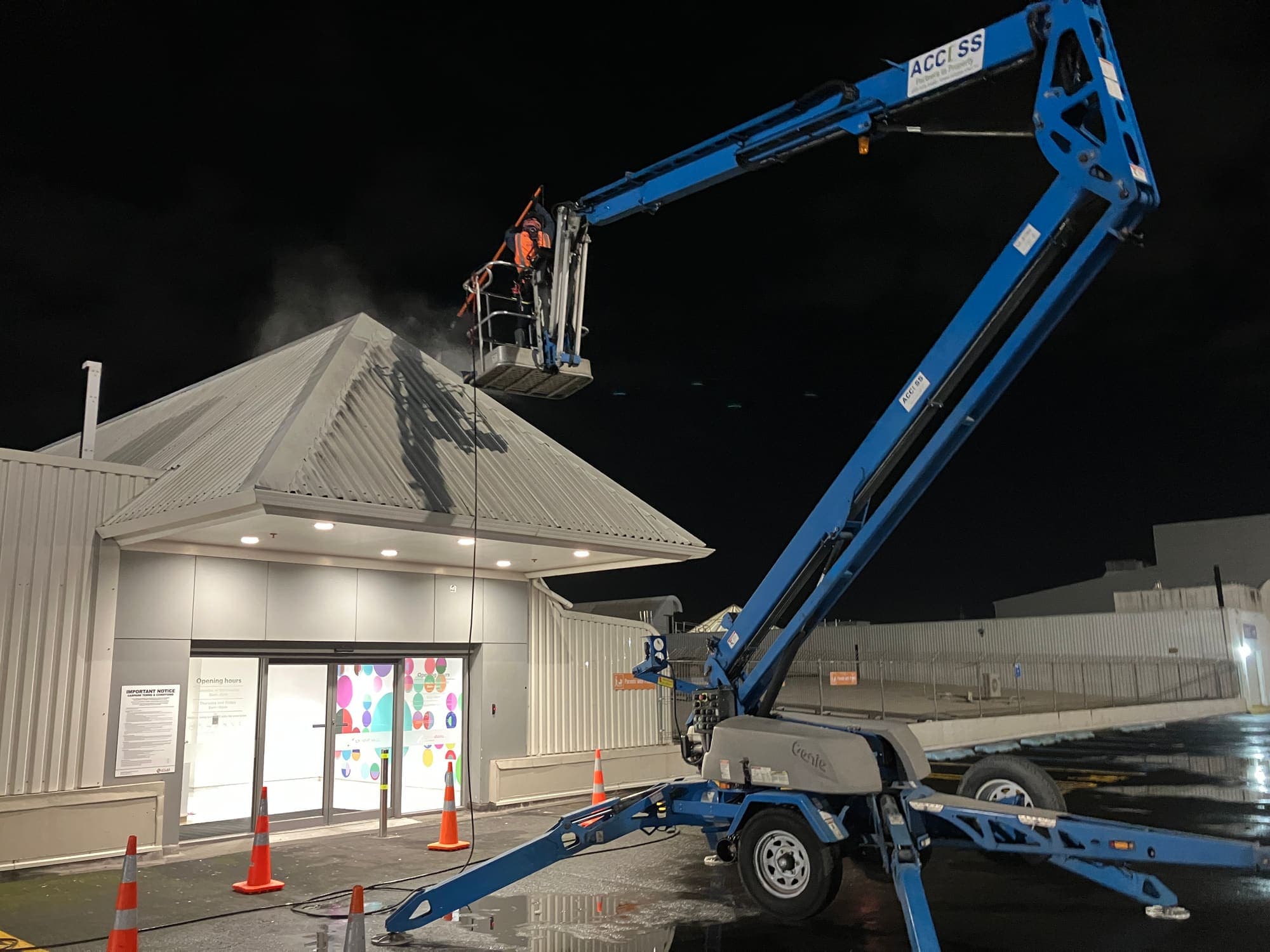 Access-branded EWP boom reaching over the LynnMall entrance canopy during the roof wash