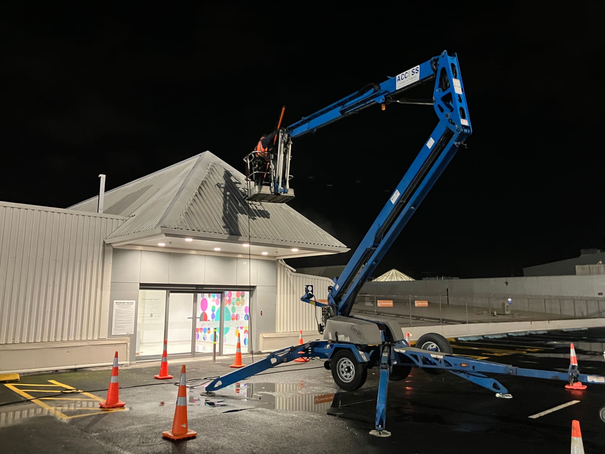Access technician in an EWP basket washing the roof above the LynnMall Shopping Centre entrance before opening hours