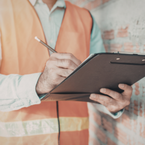 Building Inspection: Inspector writing on clipboard. Property maintenance and building surveys website icon.